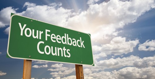 Green sign against a cloudy sky with text reading Your Feedback Counts