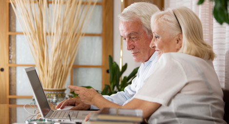 Older couple looking at a laptop screen and pointing